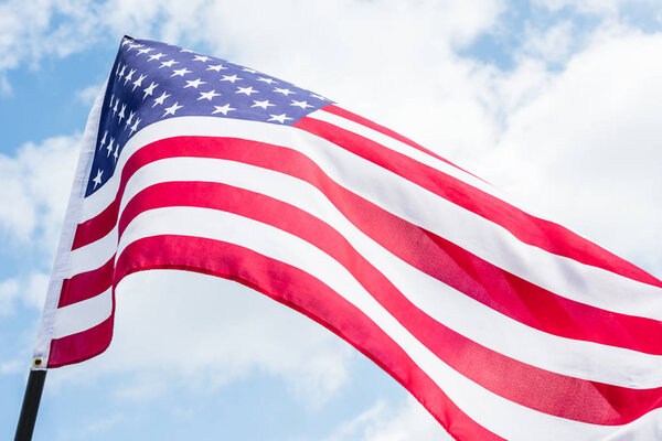 low angle view of american flag with stars and stripes against blue sky