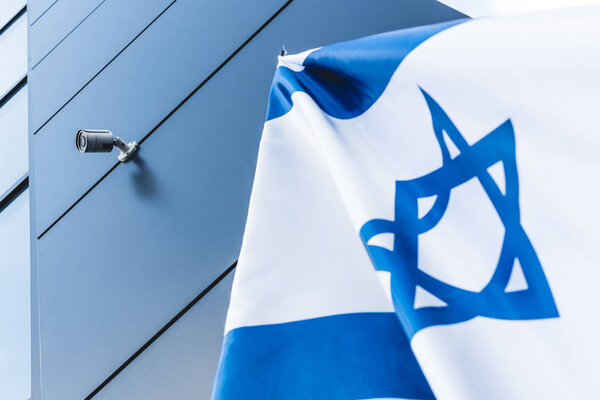 низкоугольный вид государственного флага Израиля со звездой Давида возле здания
 