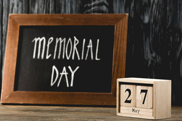 кубики с датой возле доски с надписью "День памяти" на деревянной поверхности
 