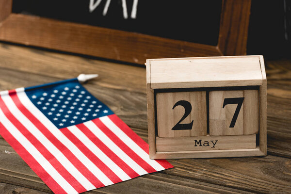 wooden cubes with date near flag of america with stars and stripes