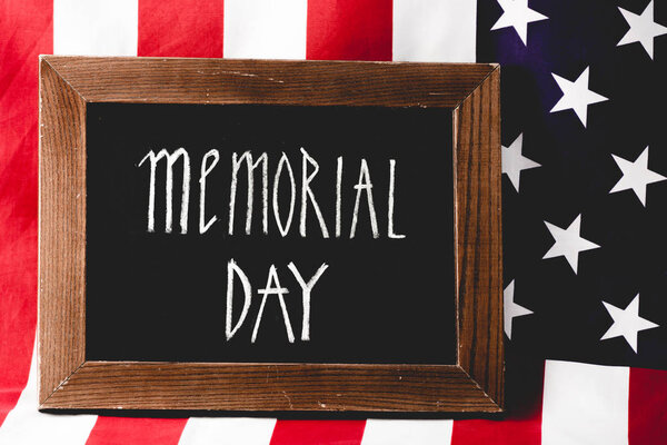 chalkboard with memorial day letters near flag of america 