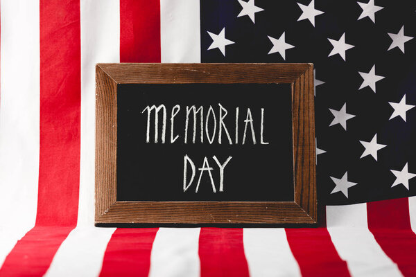 chalkboard with memorial day letters near national flag of america 