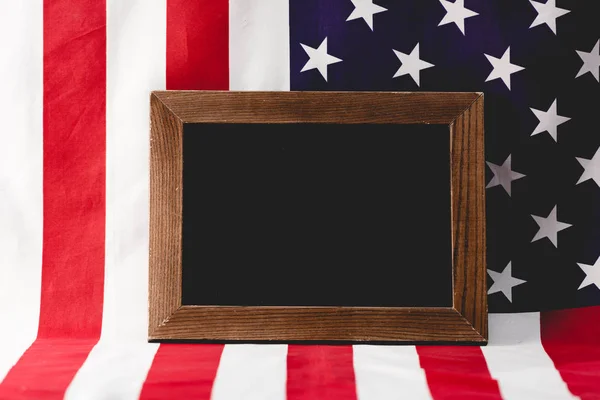 empty chalkboard near national flag of america