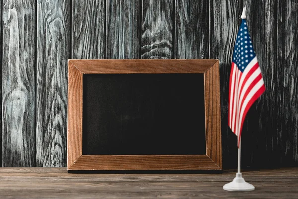empty chalkboard near american flag with stars and stripes