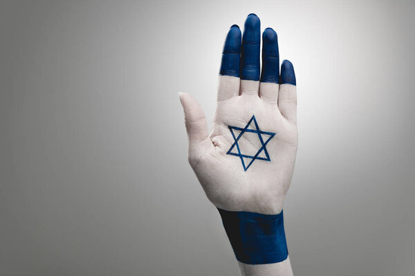 cropped view of female hand with blue star of david on grey