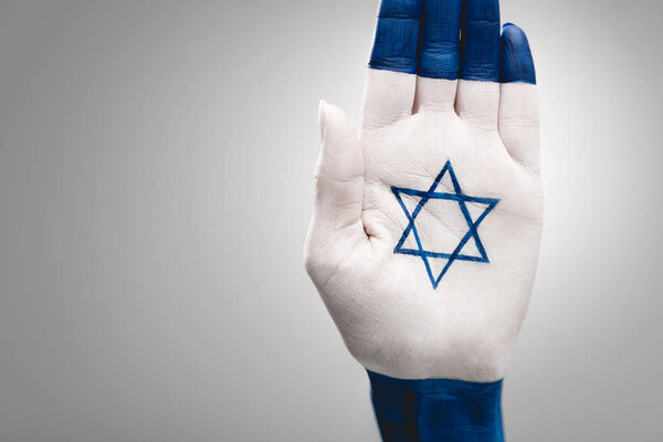 cropped view of female hand with jewish star of david on grey