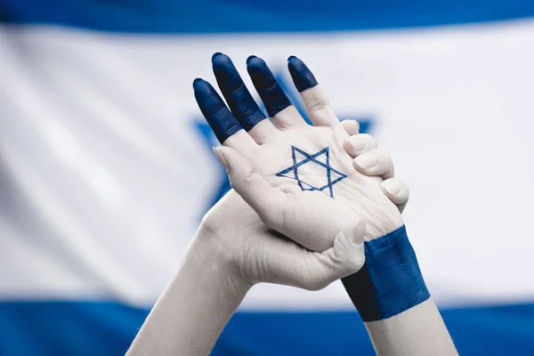 cropped view of female hands with star of david  near flag