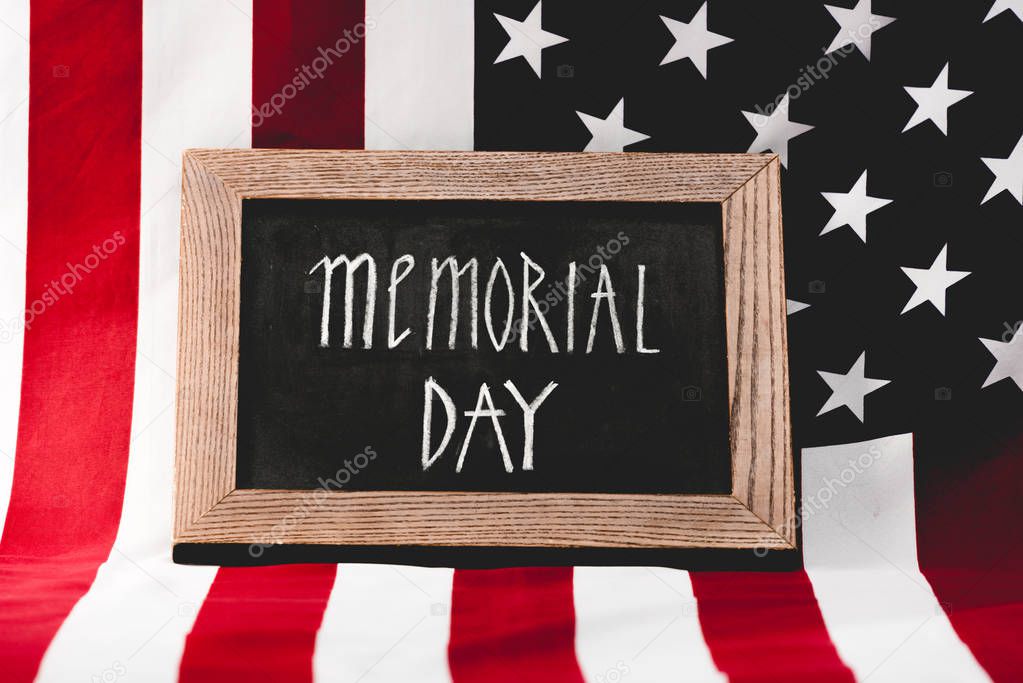 chalkboard with memorial day lettering near flag of america with stars and stripes
