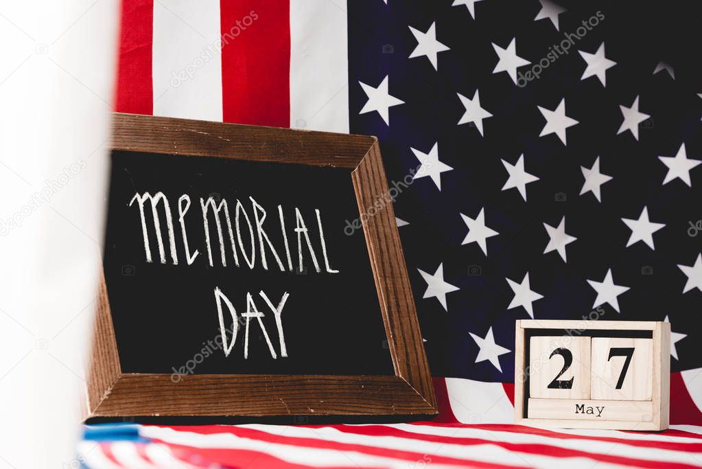 black board with memorial day letters near flag of america and cubes with date