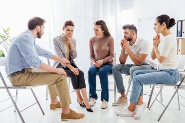 people sitting on chairs and having group therapy meeting clipart