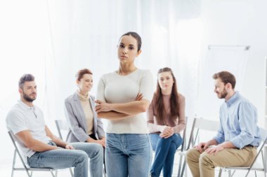 kadın kolları olan grup terapi seansı sırasında sandalyelere oturan insanlar ise kamera bakarak geçti