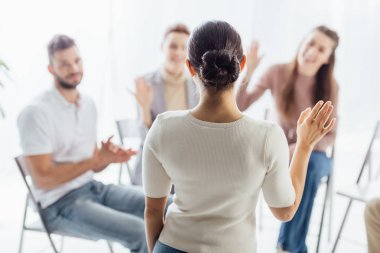 insanlar oturuyor ve grup terapi seansı sırasında eller yükselterek