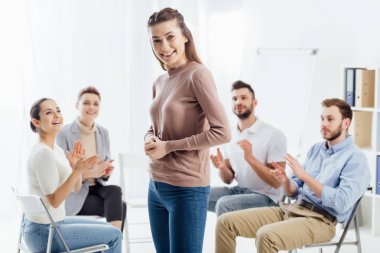 gülümseyen kadın kamera ise oturma ve grup terapi seansı sırasında alkışlamak insanlar arıyorum