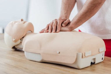 Adamın göğüs sıkıştırma teknikle kukla üzerinde cpr eğitim sırasında kısmi görünümü 