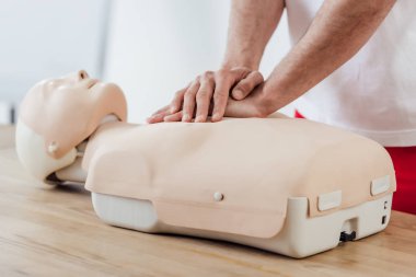 Adamın göğüs sıkıştırma teknikle kukla üzerinde cpr eğitim sırasında kısmi görünümü 