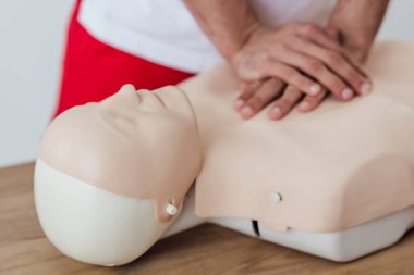 cropped view of man using chest compression technique on dummy during cpr training  clipart