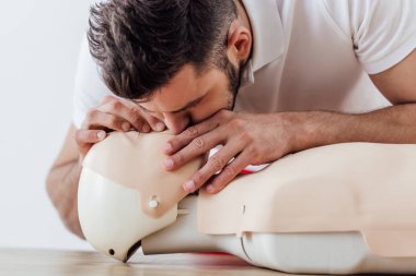 man using mouth to mouth technique on dummy during cpr training  clipart
