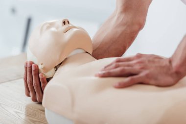 cpr ilk yardım eğitimi sırasında pratik yaparken kukla tutan adamın kısmi görünümü