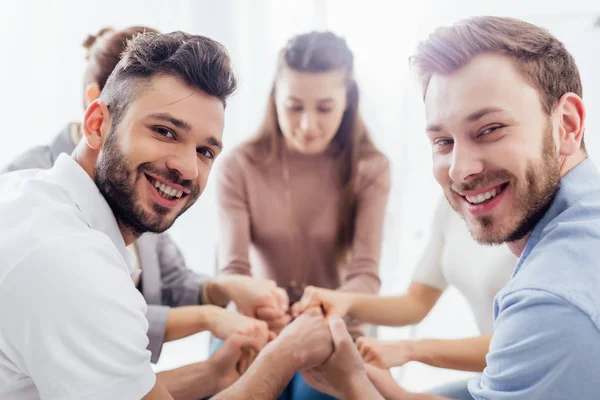 Grupo Pessoas Sentadas Sorrindo Empilhando Mãos Durante Sessão Terapia — Fotografia de Stock