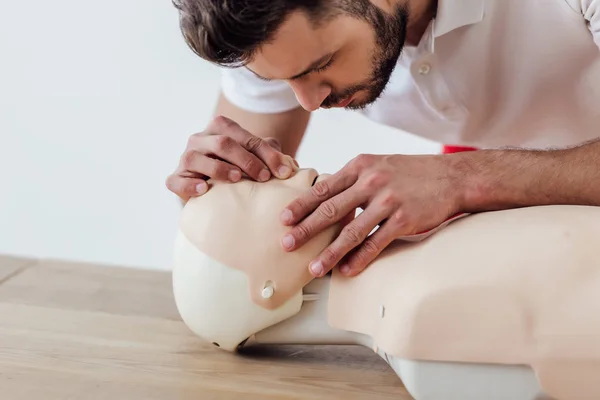 男子使用嘴对嘴技术的假人在 Cpr 训练隔离在灰色 — 图库照片