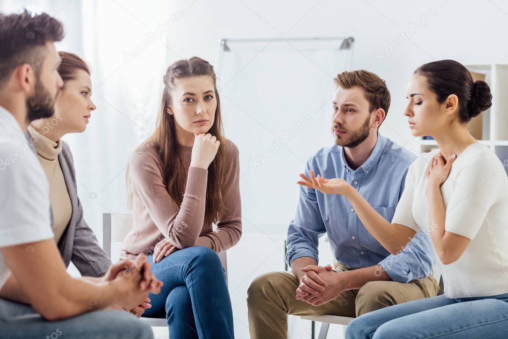 people sitting on chairs and having discussion during support group meeting