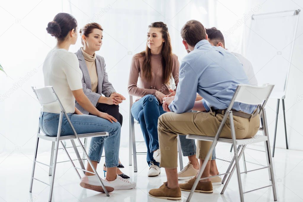 people sitting in circle during support group therapy meeting
