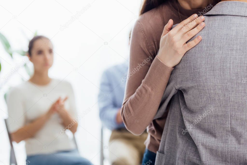 cropped view of woman embracing another woman during therapy meeting with copy space