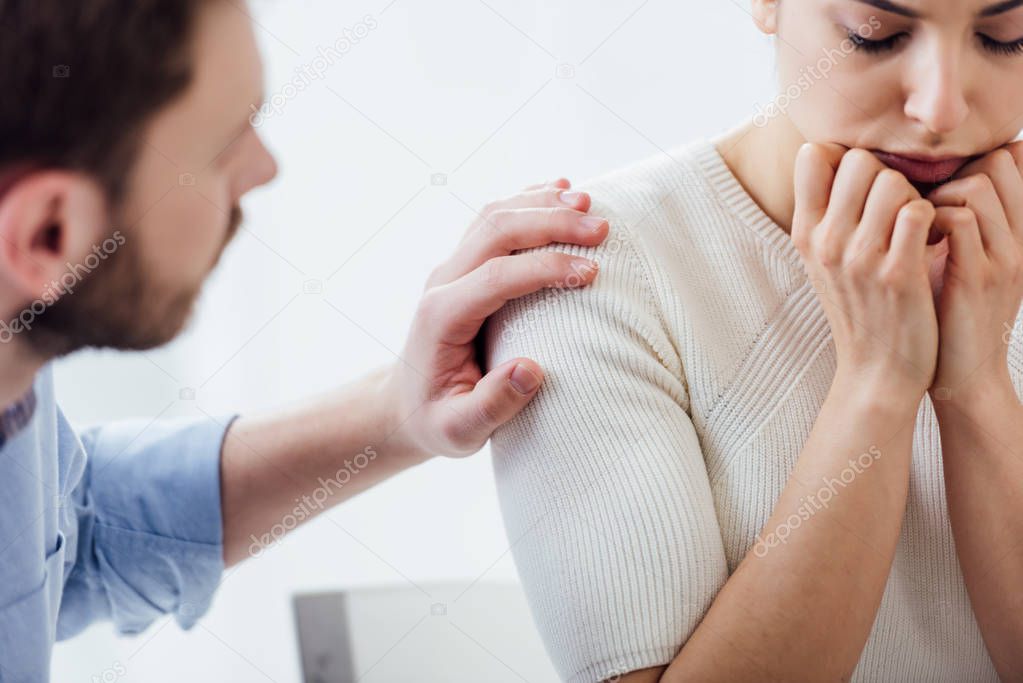 cropped view of man consoling woman during therapy meeting