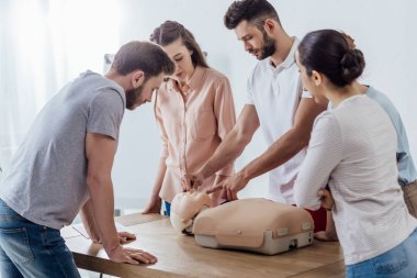 Grup cpr ilk yardım eğitim sınıf sırasında kukla ile yoğun insan