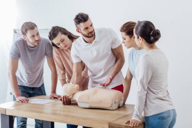 Grup cpr ilk yardım eğitim sınıf sırasında kukla ile insan