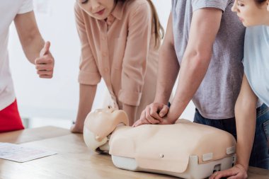 Adamın göğüs sıkıştırma kukla üzerinde cpr eğitim sınıf sırasında gerçekleştirerek kırpılmış görünümü 
