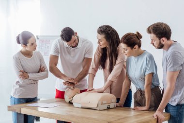Grup dersi cpr ilk yardım eğitimi sırasında kukla üzerinde performans ile insan
