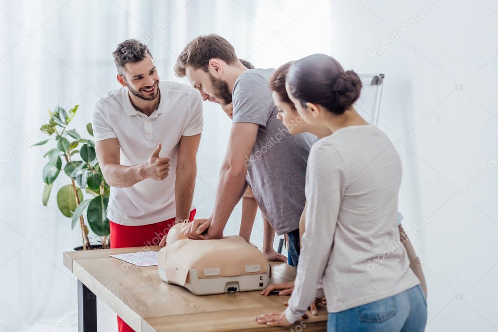 group of people with cpr dummy during first aid training class