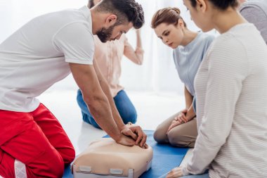 bir grup insan ile ilk yardım eğitimi sırasında kukla üzerinde CPR performans eğitmen