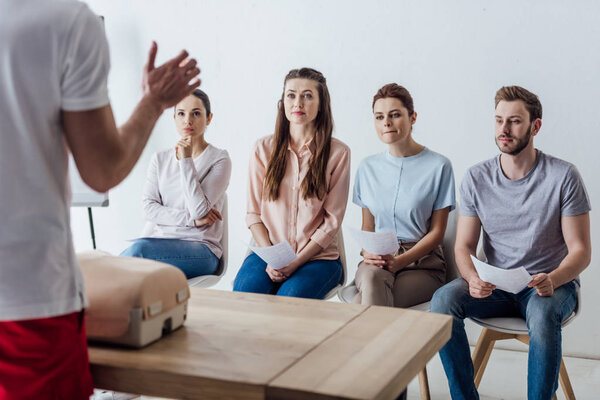 группа людей с инструктором по компьютерной грамотности во время занятий по оказанию первой помощи

