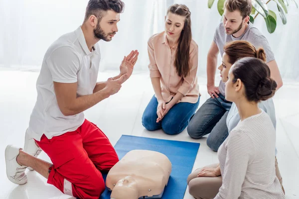 Bonito Instrutor Gesto Durante Treinamento Primeiros Socorros Com Grupo Pessoas — Fotografia de Stock