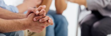 panoramic shot of hands of man during group therapy session with copy space