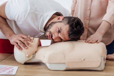 CPR ilk yardım eğitim sınıf sırasında kukla üzerinde pratik adam