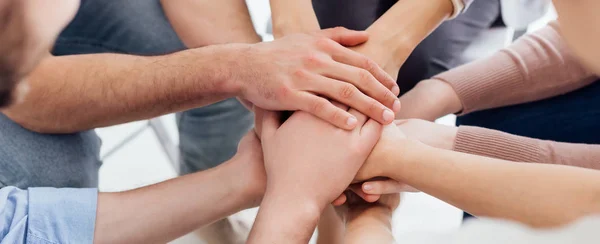 グループ療法のセッション中に手を積み重ねる人々 のパノラマ撮影 — ストック写真