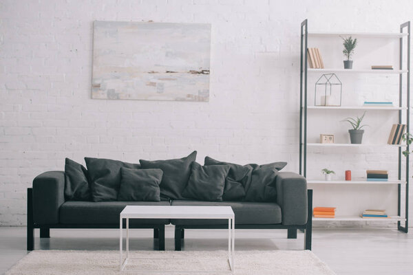 black sofa near coffee table and rack in modern living room 