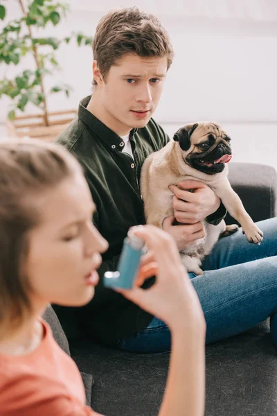 愛らしいパグを押し 吸入器を使用して犬にアレルギーの女性を見て男性の選択と集中 — ストック写真