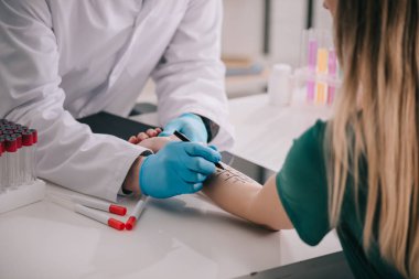 Beyaz önlük ve lateks eldiven işaretli el yakınındaki marker kalem tutan doktor görünümünü kırpılmış  