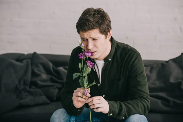 Bonito Homem Cheirando Flor Enquanto Sentado Casa — Fotografia de Stock