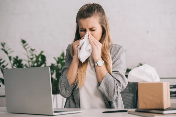 Blonde Zakenvrouw Niezen Weefsel Buurt Van Laptop Kantoor — Stockfoto