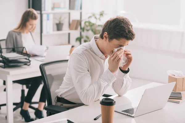 Selective Focus Businessman Sneezing Tissue While Looking Laptop Businesswoman Office — Stock Photo, Image