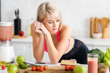 Mutfakta pasta bakarak spor giyim çekici sarışın kız 