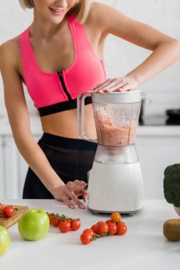 neşeli sporcu blender Smoothie hazırlanıyor kırpılmış görünümü 