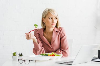 Laptop yakın brokoli ile çekici Freelancer tutan çatal
