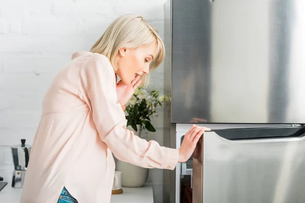 Удивлённая Беременная Блондинка Смотрит Холодильник Кухне — стоковое фото