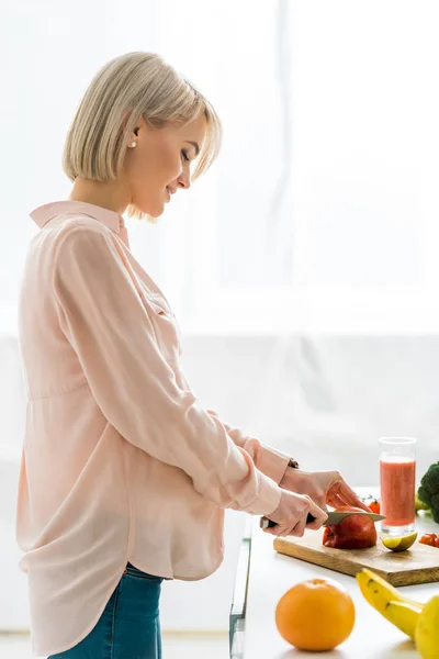Happy Blonde Pregnant Woman Cutting Apple Chopping Board — Stock Photo, Image
